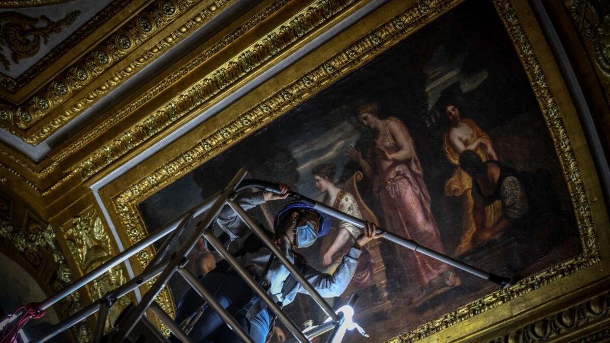 An employee wearing a protective face mask cleans the Queen's grand appartment at the Chateau de Versailles (Palace of Versailles) in Versailles near Paris, on June 5, 2020 on the eve of it re-opening after 82 days of closure due to the novel coronavirus (COVID-19) outbreak. The Palace of Versailles -- France's big tourist attraction with nearly 10 million tourists a year - will open on June 6 with no US or Asia tourists who represent 30% of its visitors. STEPHANE DE SAKUTIN / AFP