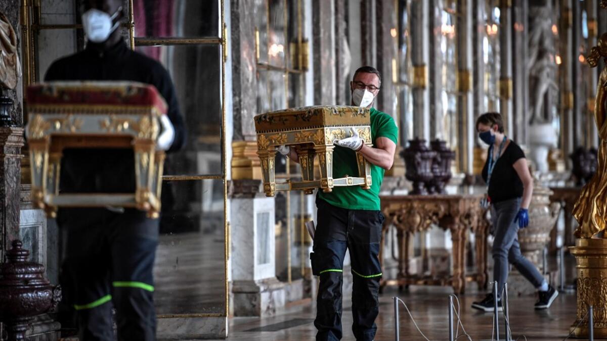 A worker carries furniture in the Galerie des Glaces (Hall of Mirrors) at the Chateau de Versailles (Palace of Versailles) in Versailles near Paris, on June 5, 2020, on the eve of it re-opening after 82 days of closure due to the novel coronavirus (COVID-19) outbreak. The Palace of Versailles -- France's big tourist attraction with nearly 10 million tourists a year - will open on June 6 with no US or Asia tourists who represent 30% of its visitors. STEPHANE DE SAKUTIN / AFP