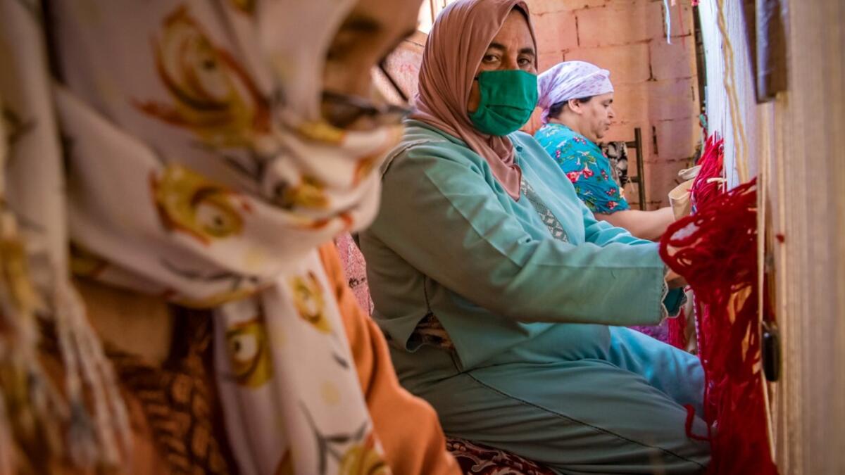 Moroccan rug weavers create a carpet at a workshop in the city of Sale, north of the capital Rabat, on June 3, 2020, during the novel coronavirus pandemic. Artisans in Morocco have been starved of income for almost three months because of the COVID-19 pandemic. The crafts industry represents some seven percent of GDP, with an export turnover last year of nearly 1 billion dirhams ($100 million). FADEL SENNA / AFP
