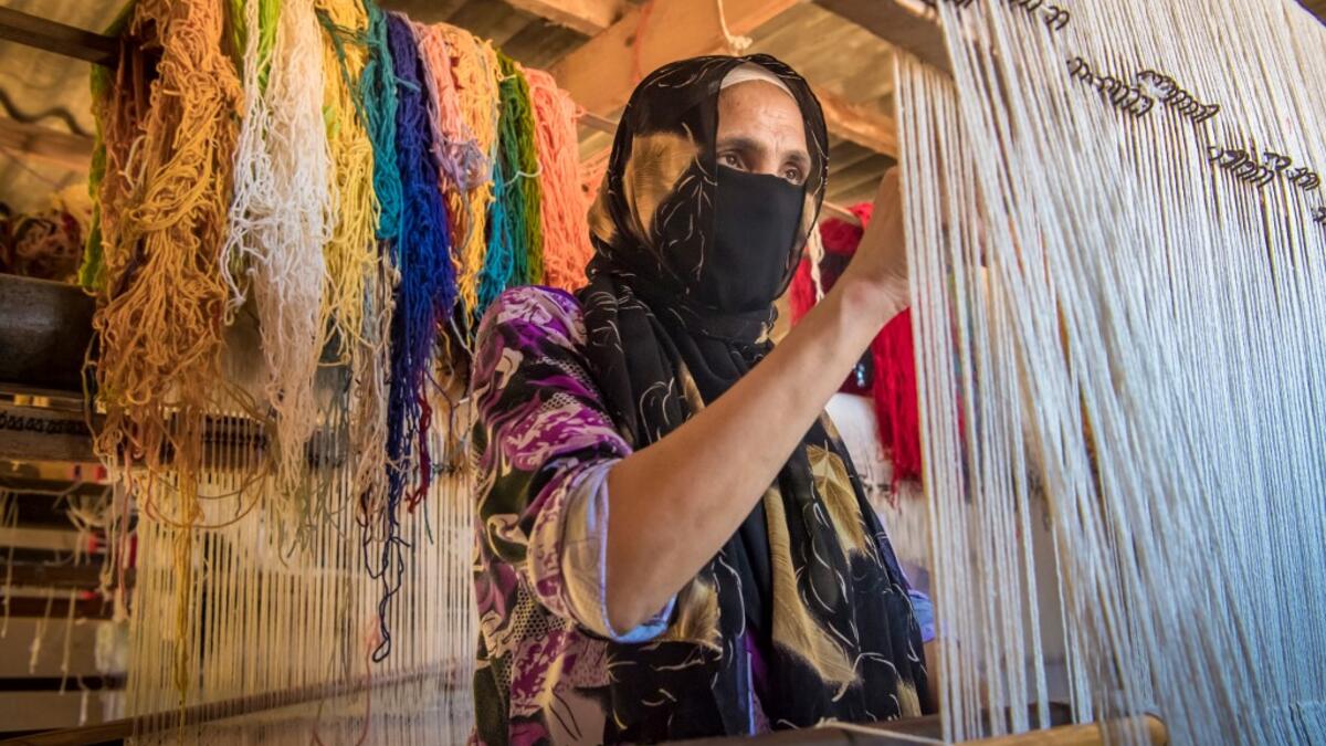 A Moroccan rug weaver creates a carpet at a workshop in the city of Sale, north of the capital Rabat, on June 3, 2020, during the novel coronavirus pandemic. Artisans in Morocco have been starved of income for almost three months because of the COVID-19 pandemic. The crafts industry represents some seven percent of GDP, with an export turnover last year of nearly 1 billion dirhams ($100 million). FADEL SENNA / AFP