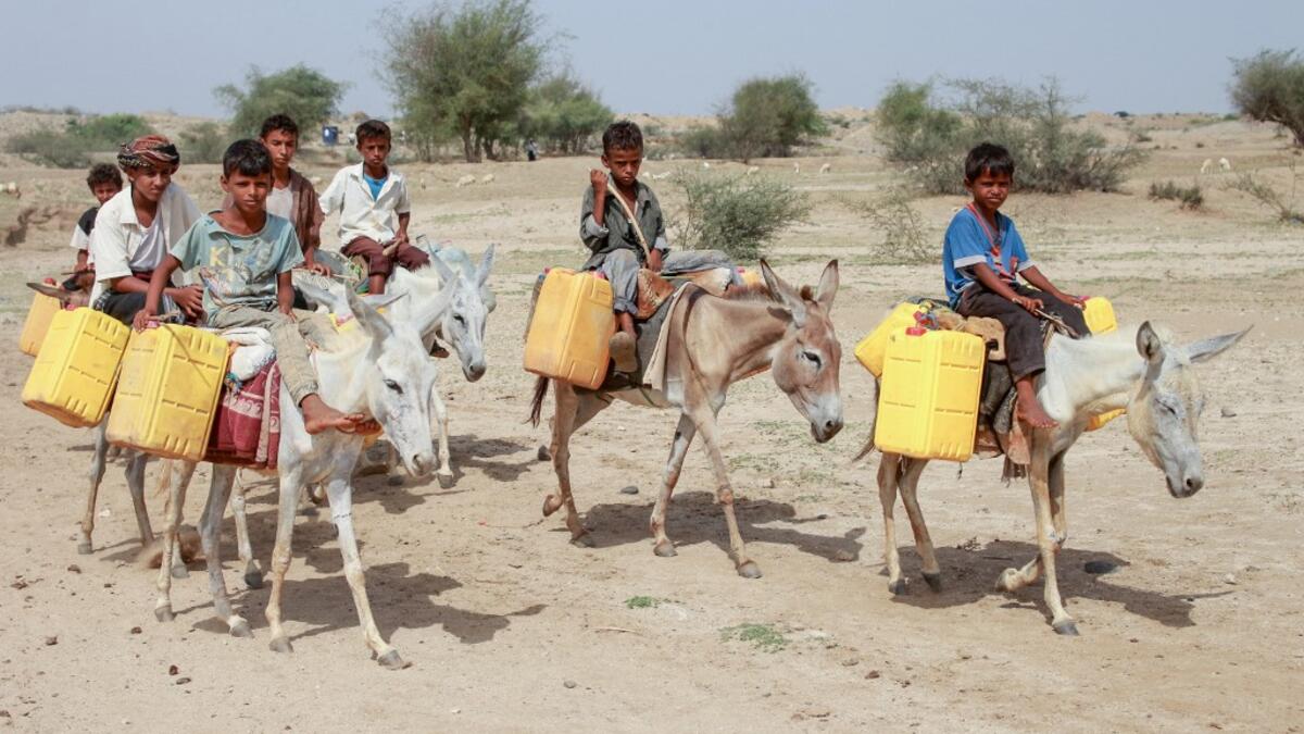 Yemeni children riding donkeys arrive to fill their jerrycans with water from a cistern at a make-shift camp for the internally displaced, in the northern Hajjah province, on June 7, 2020, amid a severe shortage of water. ESSA AHMED / AFP