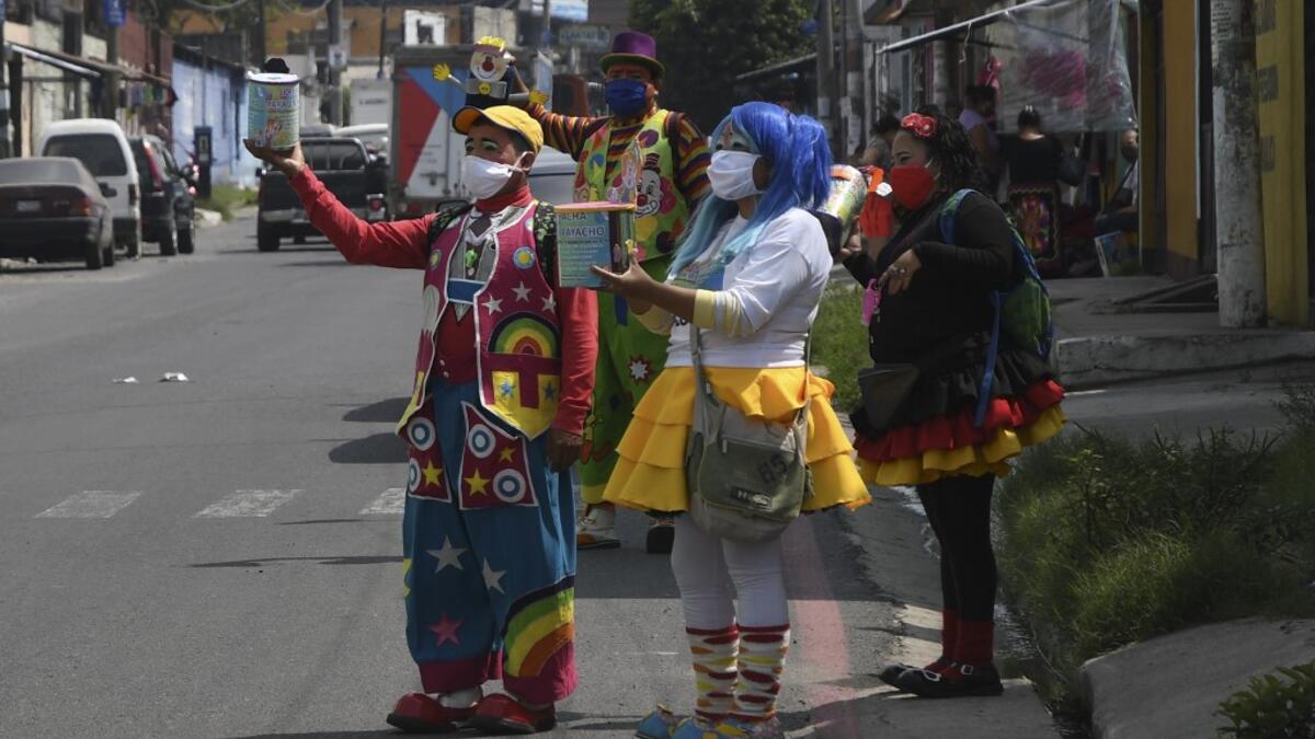 A group of clowns beg for money to survive the crisis caused by the new coronavirus in Villa Nueva, 20 km south Guatemala City, on June 10, 2020, as clowns have been unable to work due to restrictions to prevent the spread of the COVID-19.    Johan ORDONEZ / AFP
