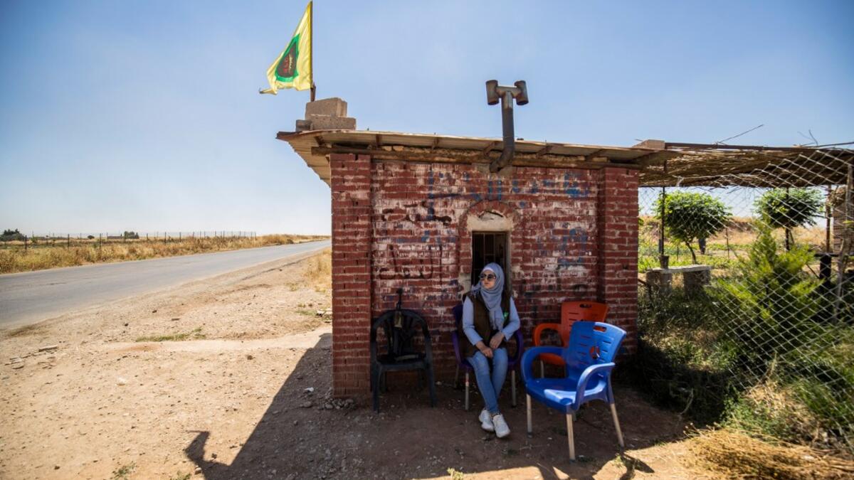 A Kurdish female volunteer, from the newly formed Community Protection Forces, guards a wheat field, against threats by jihadists to burn the crops, during harvest season on June 13, 2020, in the countryside east of Qamishli in Syria's northeastern Hasakah province. Delil SOULEIMAN / AFP