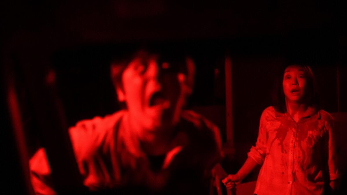 But this drive-in haunted house in Japan protects against the most terrifying enemy of all -- coronavirus. Inside a car, guests can scream as loudly as they like, with no mask required, as hideous creatures daubed in blood swarm towards them.  Philip FONG / AFP