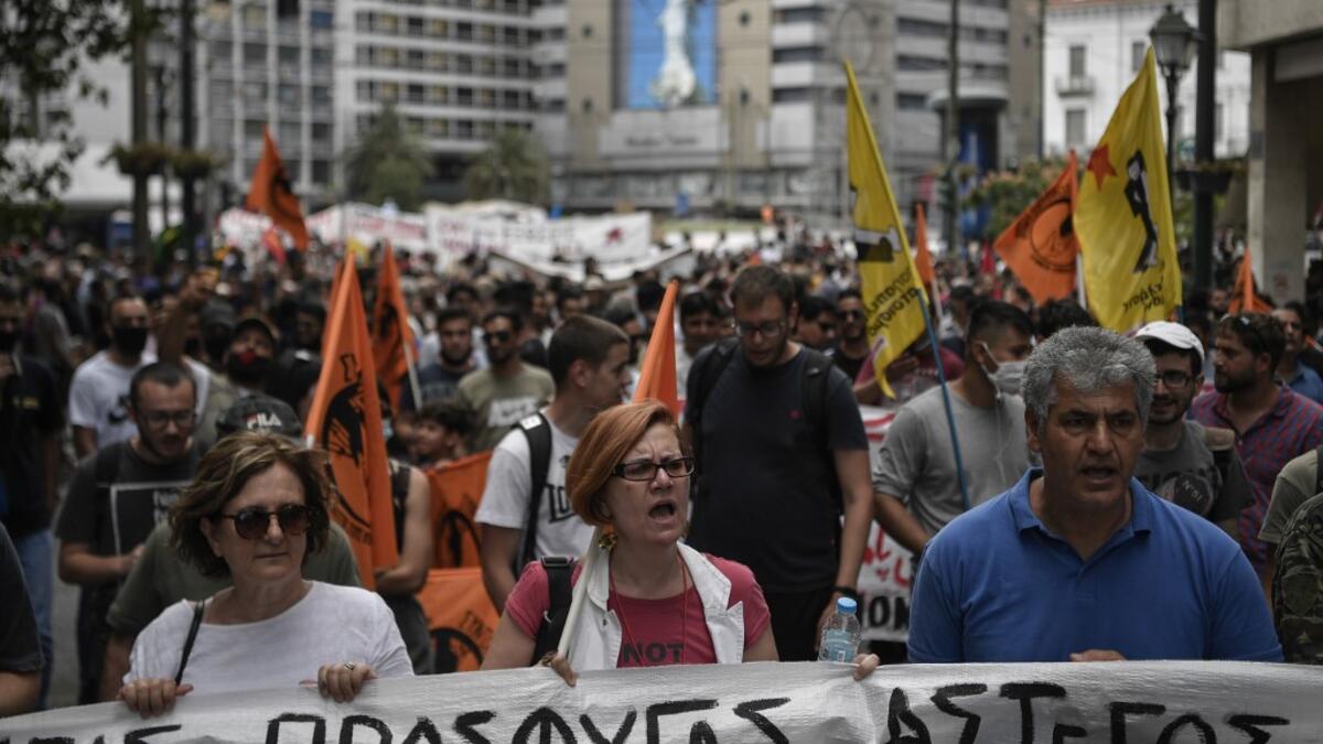 Solidarity groups and NGO's march behind banners as they participate in a rally in Athens on June 20, 2020, marking World Refugee Day as they demand rights and housing for refugees and migrants in Greece. Louisa GOULIAMAKI / AFP