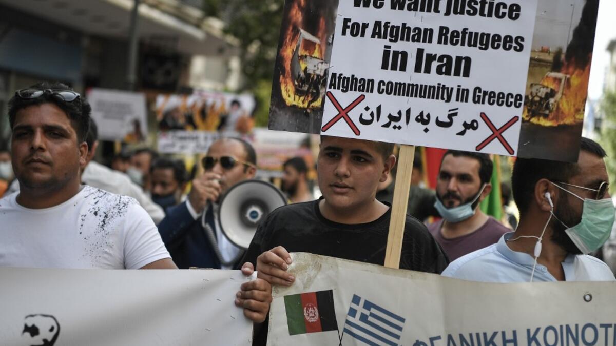 Afghans living in Athens carry a placard, demanding rights for Afghan refugees in Iran, as they participate with others in a rally in Athens on June 20, 2020, marking World Refugee Day, demanding rights and housing for refugees and migrants in Greece. Louisa GOULIAMAKI / AFP