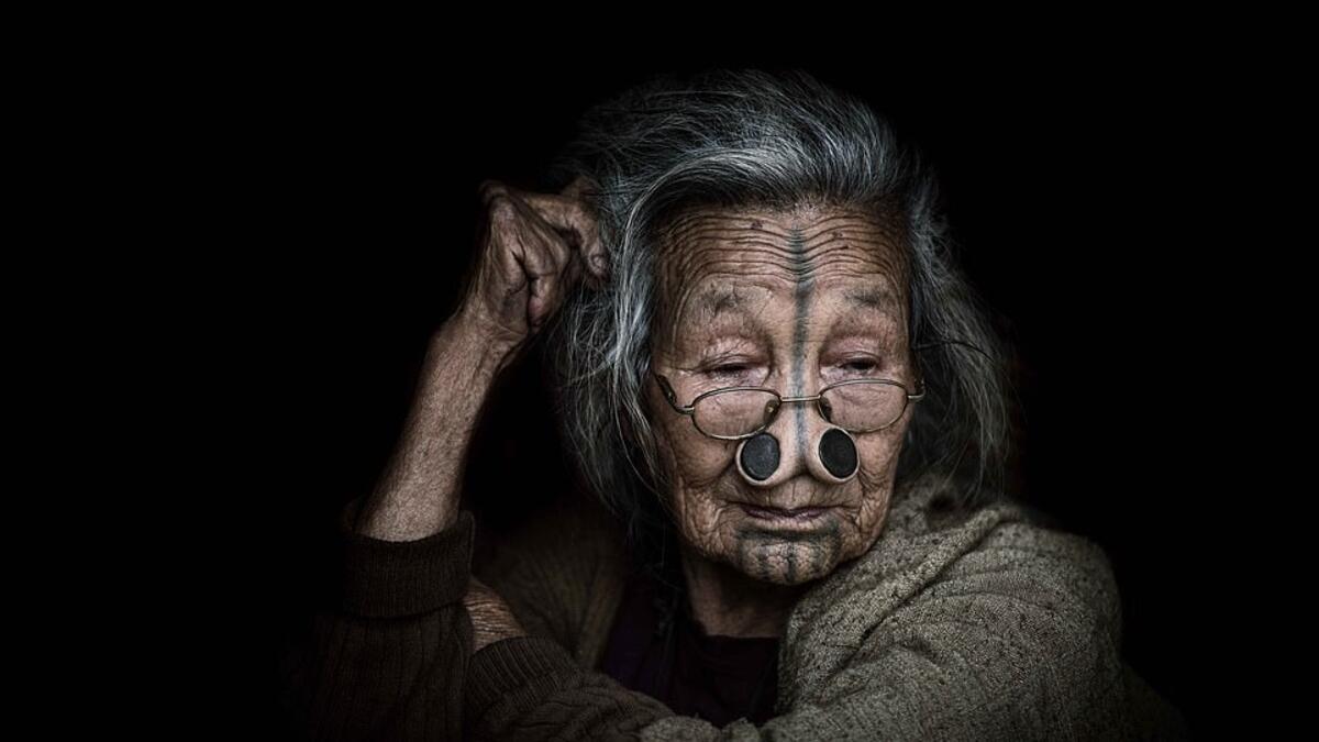 Another woman, also wearing nose plugs, was photographed wearing glasses and more modern modern clothes, suggesting the tribe lost its untouched nature long ago. (Mediadrumimages/ Trevor Cole)