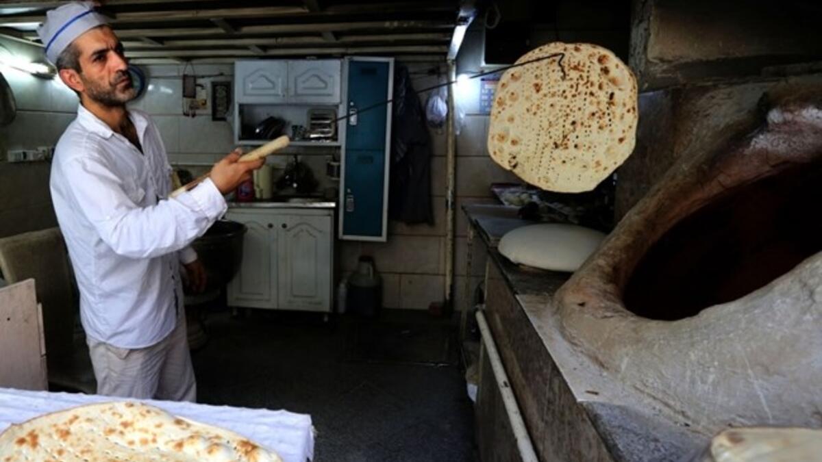 Iranian baker Mohammad Mirzakhani, 41, makes Taftoon bread in Tehran on June 13, 2020. ATTA KENARE / AFP