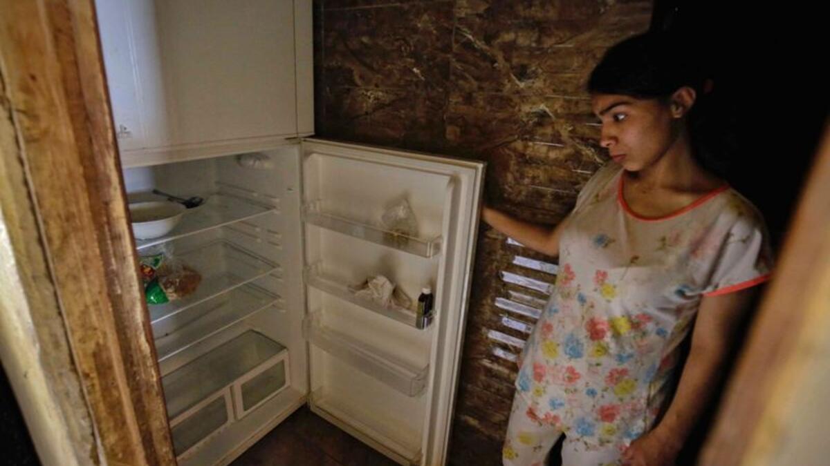 Those who accepted to be photographed posed in front of open refrigerators whose bare shelves often hinted at the leanest of diets. Image Credit: AFP