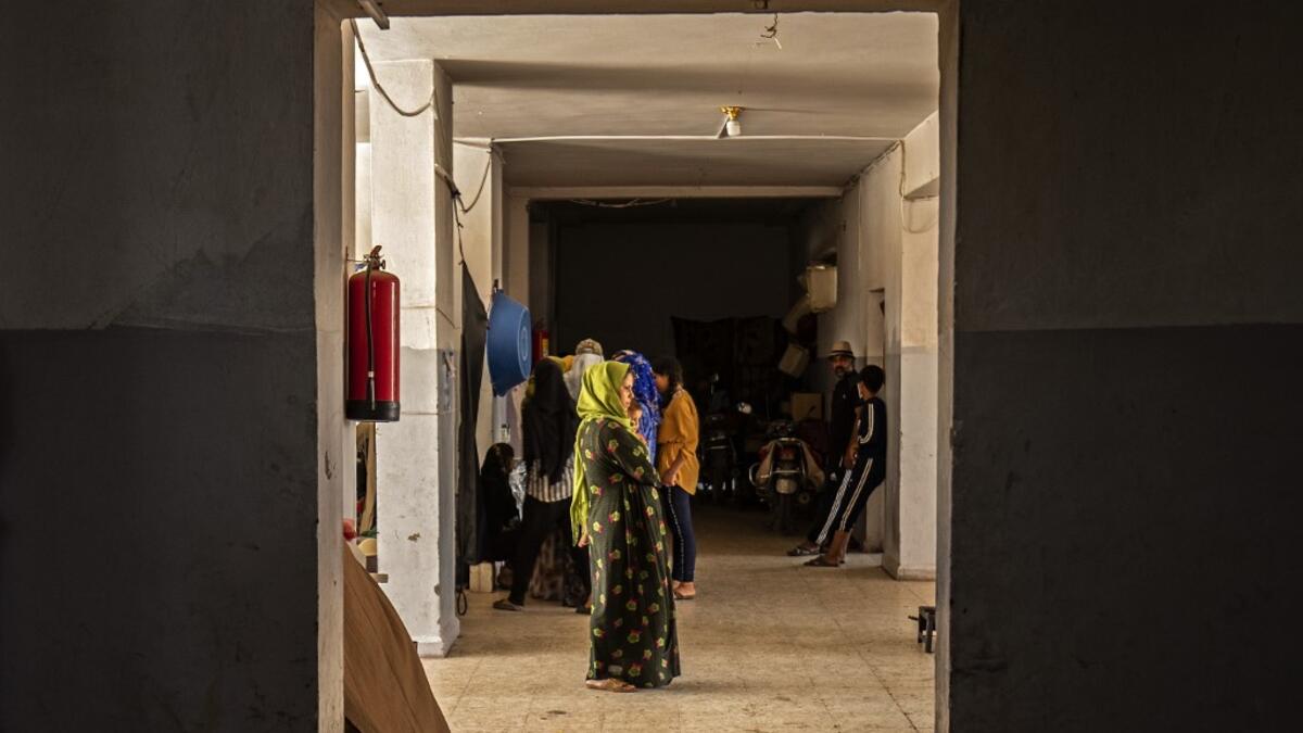 People stand in a hallway at a school building where Syrians -- displaced from the area of Ras al-Ain by the Turkish offensive on the northeast -- are staying in the city of Hasakah, on June 30, 2020. Delil SOULEIMAN / AFP