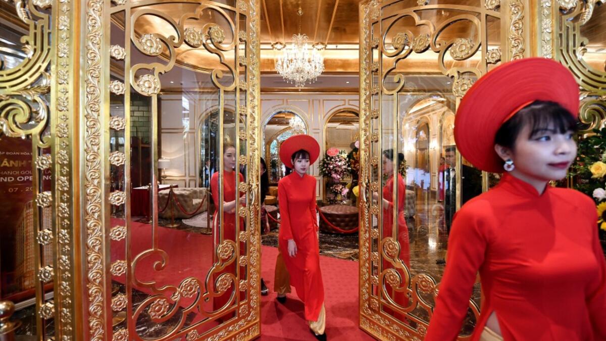 Staff wait to welcome guests in the lobby of the newly-inaugurated Dolce Hanoi Golden Lake hotel, the world's first gold-plated hotel, in Hanoi on July 2, 2020. Manan VATSYAYANA / AFP