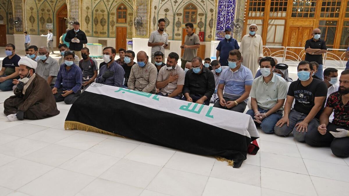 Mourners pray over the coffin of slain Iraqi jihadism expert Hisham al-Hashemi, who was shot dead yesterday outside his house in the Iraqi capital, before his burial on July 7, 2020 in the Shiite shrine city of Najaf in central Iraq. The killing of the 47-year-old prominent expert has stirred fears Iraq is entering a dark and violent phase, as boiling tensions between pro-Iran factions and the government reach new heights. AFP
