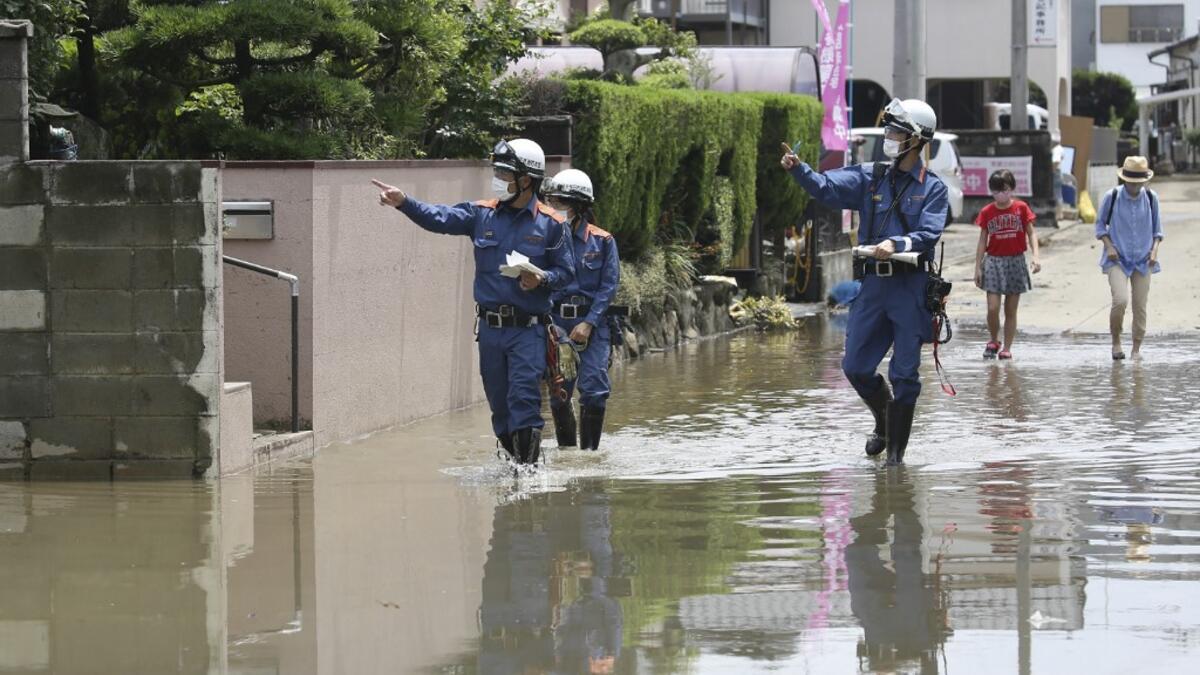 Fire brigade officers check on residents following heavy rain in Omuta, Fukuoka Prefecture on July 8, 2020. Torrential rain pounded central Japan on July 8 as authorities said 58 people were feared dead in days of heavy downpours that have triggered devastating landslides and terrifying floods. STR / JIJI PRESS / AFP