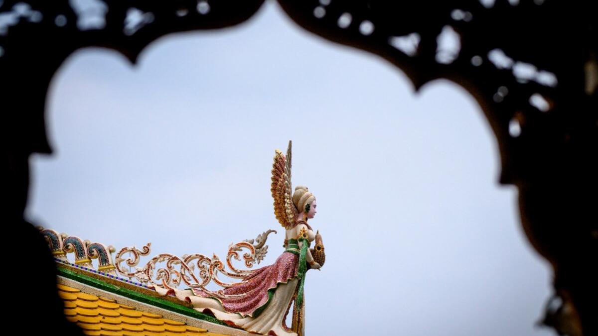 This photograph taken on July 14, 2020 shows a detail on the roof of the Wat Pariwat Buddhist temple in Bangkok. Wat Pariwat, also known as "the David Beckham Temple", is decorated with statues of superheroes and comic characters as well as mythical and imaginary creatures. A golden-plated sculpture of the English football player holding the base of a Buddha statue in one of the buildings gives the temple its nickname.