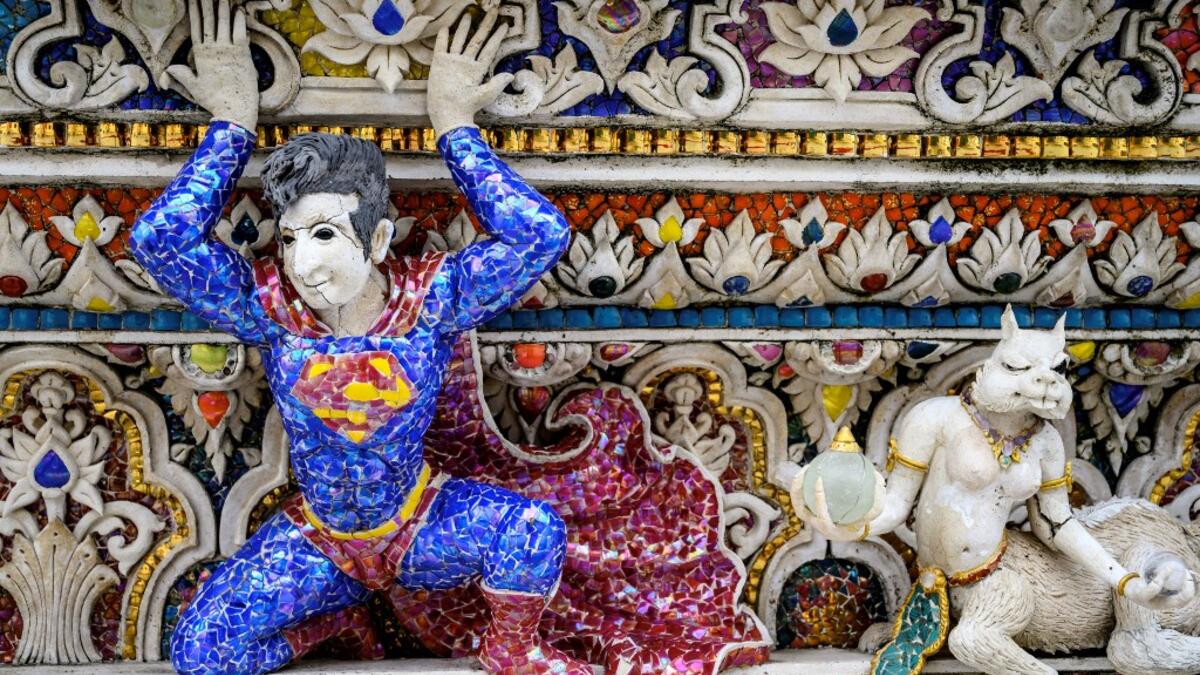 This photograph taken on July 14, 2020 shows a figure of Superman on the facade of the Wat Pariwat Buddhist temple in Bangkok. Wat Pariwat, also known as "the David Beckham Temple", is decorated with statues of superheroes and comic characters as well as mythical and imaginary creatures. A golden-plated sculpture of the English football player holding the base of a Buddha statue in one of the buildings gives the temple its nickname. Mladen ANTONOV / AFP