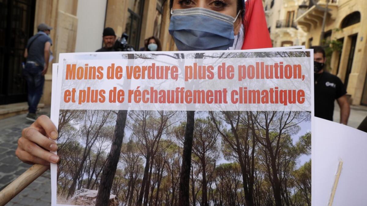 A demonstrator holds a placard as tshe takes part in a rally in front of the World Bank offices in the downtown district of the Lebanese capital Beirut on July 25, 2020, to protest against the Bisri dam project, partly financed by the World Bank. The government says the Bisri dam is vital to tackling chronic water shortages. But activists say it will ravage most of the region's farmland and historic sites, and they also fear the consequences of building it on a seismic fault line.  ANWAR AMRO / AFP