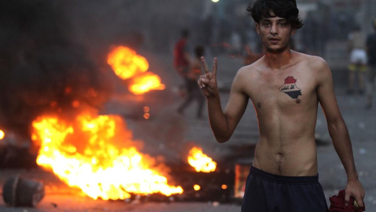 An Iraqi demonstrator gestures during clashes with security forces in al-Tayaran square in central Baghdad on July 27, 2020 during the ongoing anti-government protest due to poor public services. AHMAD AL-RUBAYE / AFP