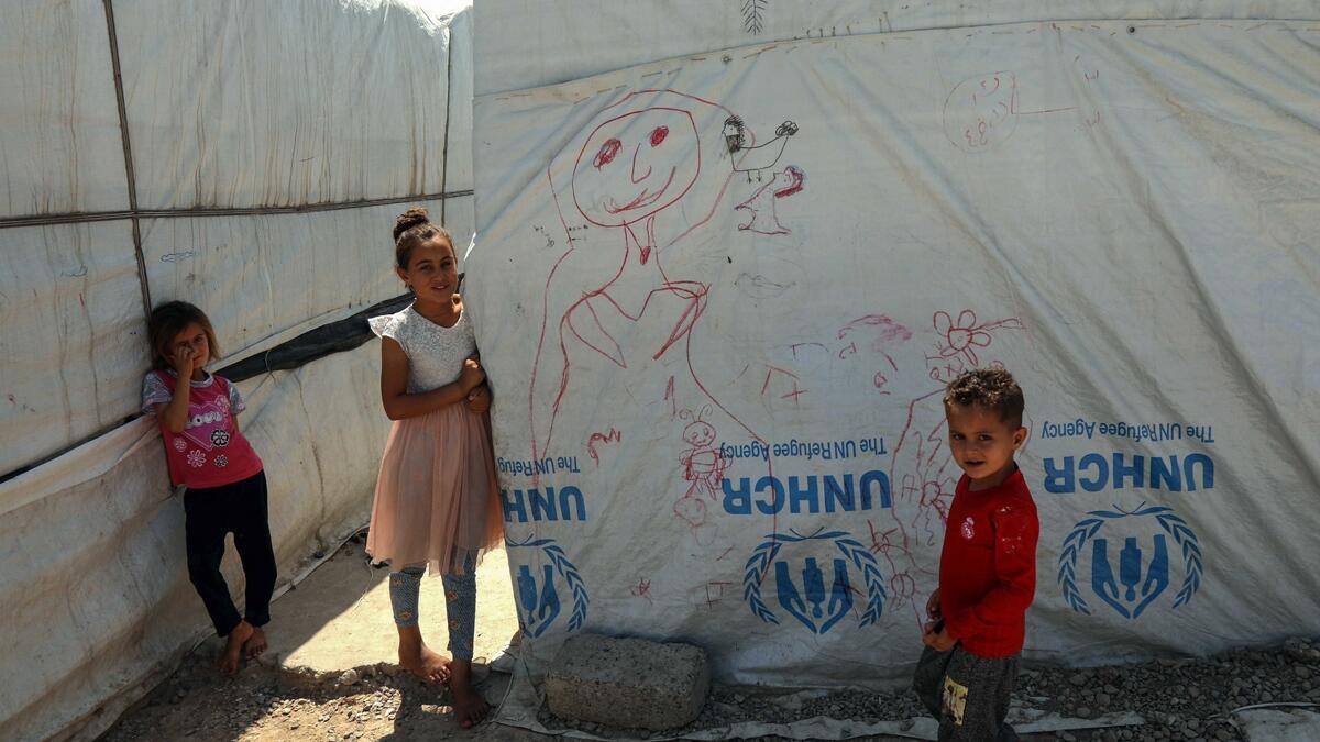 Displaced Iraqi Yazidi children stand next to a tent at a camp in Khanke, a few kilometres from the Turkish border in Iraq's Dohuk province, on June 24, 2019. (AFP / Safin Hamed)