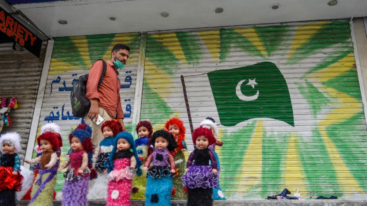 A man walks past a shuttered market in Rawalpindi on July 29, 2020, after the Punjab province government announced a lockdown closing markets, shopping malls and plazas to contain the spread of the COVID-19 coronavirus on the occasion of the Muslim festival Eid al-Adha or the 'Festival of Sacrifice'. Farooq NAEEM / AFP