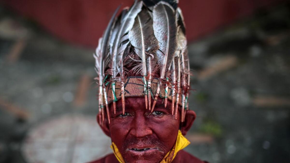 A Catholic faithful painted in red ink poses for a picture as he takes part in the opening of the ten-day celebration of the Santo Domingo de Guzman festival, outside the Las Sierritas de Santo Domingo church in Managua, on August 1, 2020 amid the COVID-19 novel coronavirus pandemic. Despite the Catholic Church cancelling all religious activities due to the coronavirus pandemic, devotees gathered outside the church for the celebration. Inti OCON / AFP