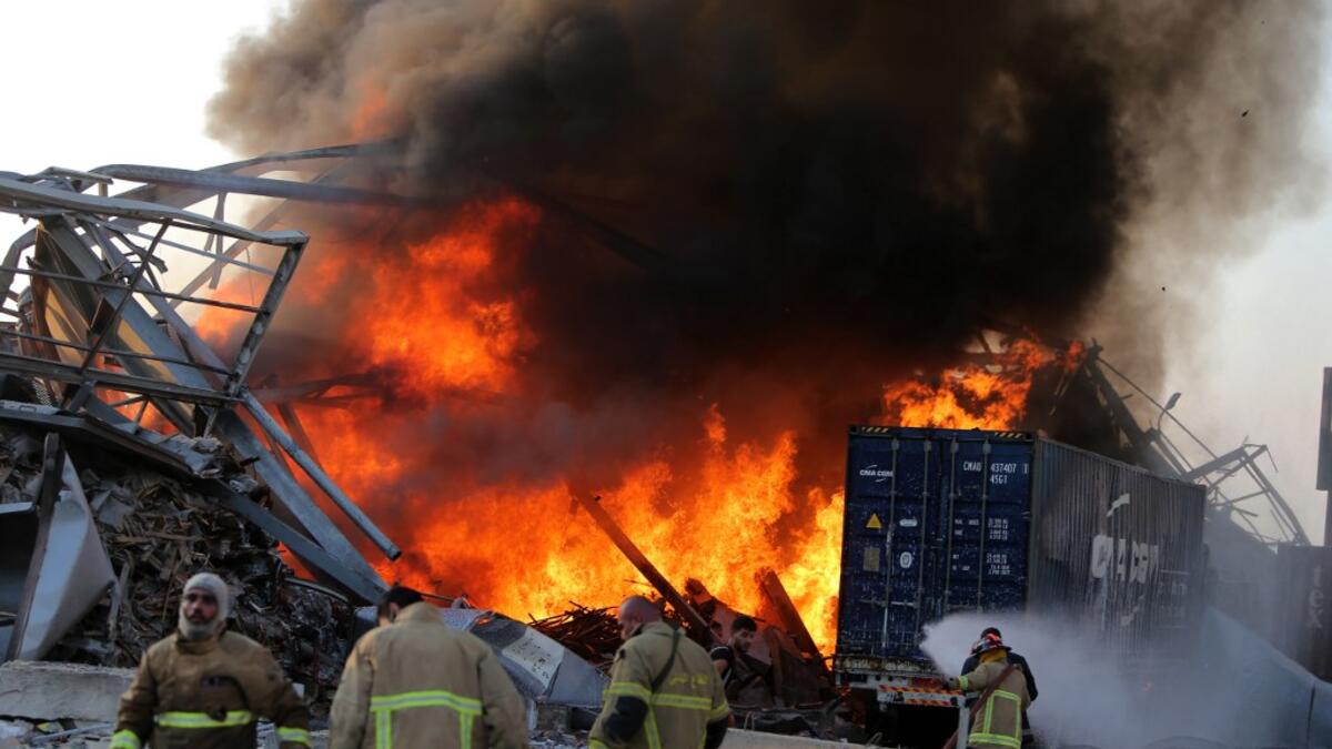 Lebanese firefights extinguish fire at the scene of an explosion at the port in the capital Beirut on August 4, 2020. Two huge explosion rocked the Lebanese capital Beirut, wounding dozens of people, shaking buildings and sending huge plumes of smoke billowing into the sky. Lebanese media carried images of people trapped under rubble, some bloodied, after the massive explosions, the cause of which was not immediately known.  STR / AFP