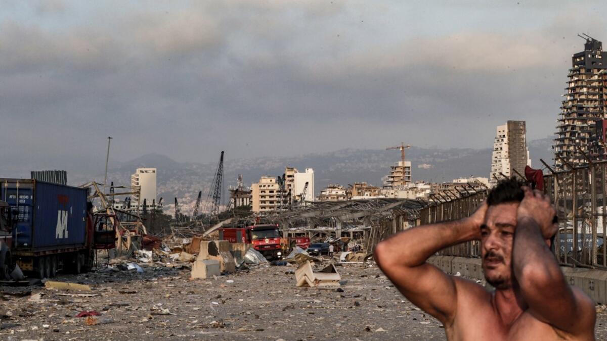 A man reacts at the scene of an explosion at the port in Lebanon's capital Beirut on August 4, 2020. Two huge explosion rocked the Lebanese capital Beirut, wounding dozens of people, shaking buildings and sending huge plumes of smoke billowing into the sky. Lebanese media carried images of people trapped under rubble, some bloodied, after the massive explosions, the cause of which was not immediately known.  IBRAHIM AMRO / AFP