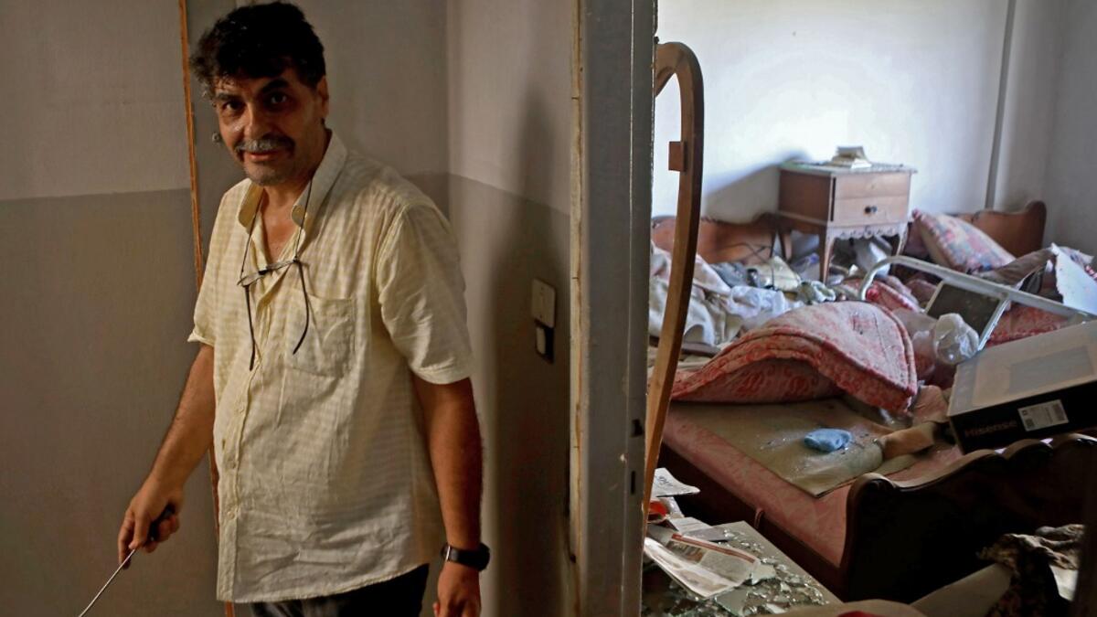 A man stands in his damaged apartment in the damaged neighbourhood of Mar Mikhael in the Lebanese capital Beirut on August 6, 2020, two days after a massive explosion shook the Lebanese capital. The blast, which appeared to have been caused by a fire igniting 2,750 tonnes of ammonium nitrate left unsecured in a warehouse, was felt as far away as Cyprus, some 150 miles (240 kilometres) to the northwest. The scale of the destruction was such that the Lebanese capital resembled the scene of an earthquake, with