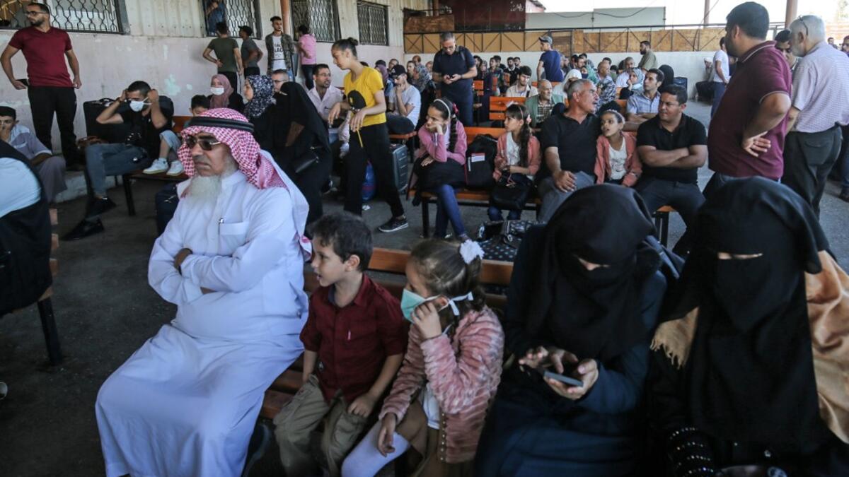 Palestinians wait to cross to the Egyptian side of Rafah border crossing after months of closure due to the coronavirus pandemic in the southern Gaza Strip, on August 11, 2020. SAID KHATIB / AFP