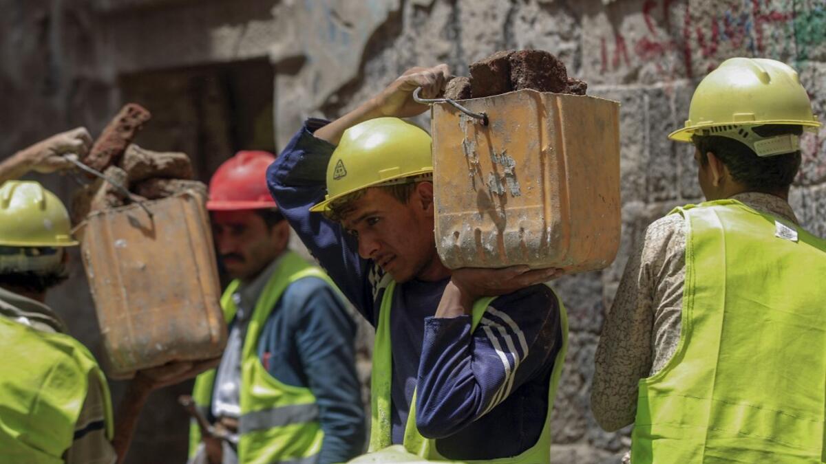 Yemeni labourers remove the rubble ahead of restoration works on the site of a collapsed UNESCO-listed building following heavy rains, in the old city of the Yemeni capital Sanaa, on August 12, 2020. Flash floods triggered by torrential rains have killed at least 172 people across Yemen over the past month, damaging homes and UNESCO-listed world heritage sites, officials said. Mohammed HUWAIS / AFP