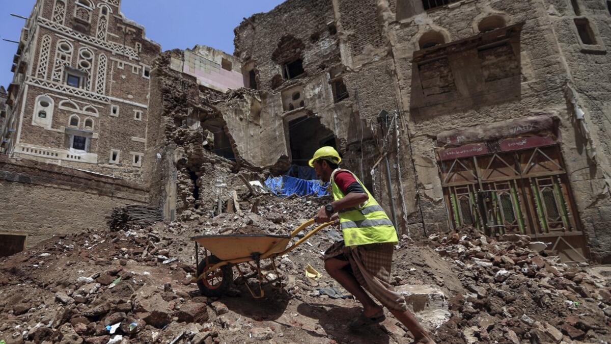 Yemeni labourers remove the rubble ahead of restoration works on the site of a collapsed UNESCO-listed building following heavy rains, in the old city of the Yemeni capital Sanaa, on August 12, 2020. Flash floods triggered by torrential rains have killed at least 172 people across Yemen over the past month, damaging homes and UNESCO-listed world heritage sites, officials said. Mohammed HUWAIS / AFP