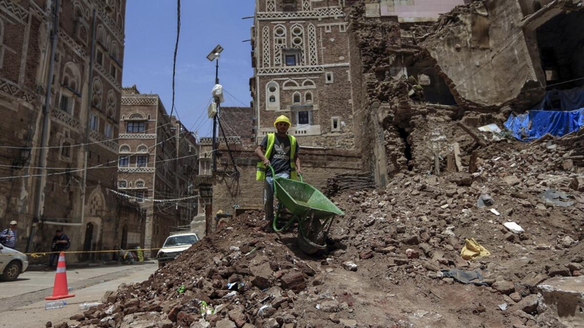 A Yemeni labourer removes the rubble ahead of restoration works on the site of a collapsed UNESCO-listed building following heavy rains, in the old city of the Yemeni capital Sanaa, on August 12, 2020. Flash floods triggered by torrential rains have killed at least 172 people across Yemen over the past month, damaging homes and UNESCO-listed world heritage sites, officials said. Mohammed HUWAIS / AFP