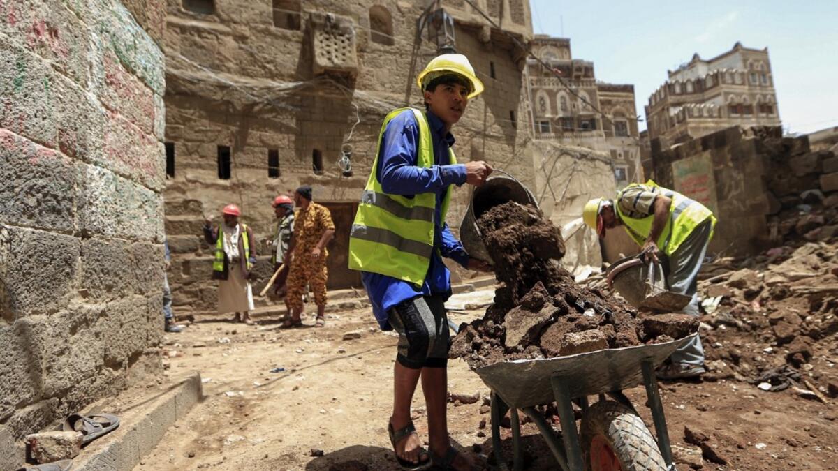 Yemeni labourers remove the rubble ahead of restoration works on the site of a collapsed UNESCO-listed building following heavy rains, in the old city of the Yemeni capital Sanaa, on August 12, 2020. Flash floods triggered by torrential rains have killed at least 172 people across Yemen over the past month, damaging homes and UNESCO-listed world heritage sites, officials said. Mohammed HUWAIS / AFP