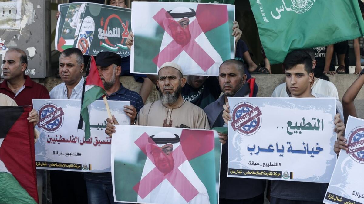 Palestinian demonstrators wave the green flag of the Hamas movement, carry pictures of Abu Dhabi's Crown Prince Sheikh Mohammed bin Zayed Al-Nahyan as well as banners with slogans against a US-brokered deal between Israel and the UAE to normalise relations, during a rally in the northern Gaza Strip refugee camp of Jabalia, on August 15, 2020. MAHMUD HAMS / AFP