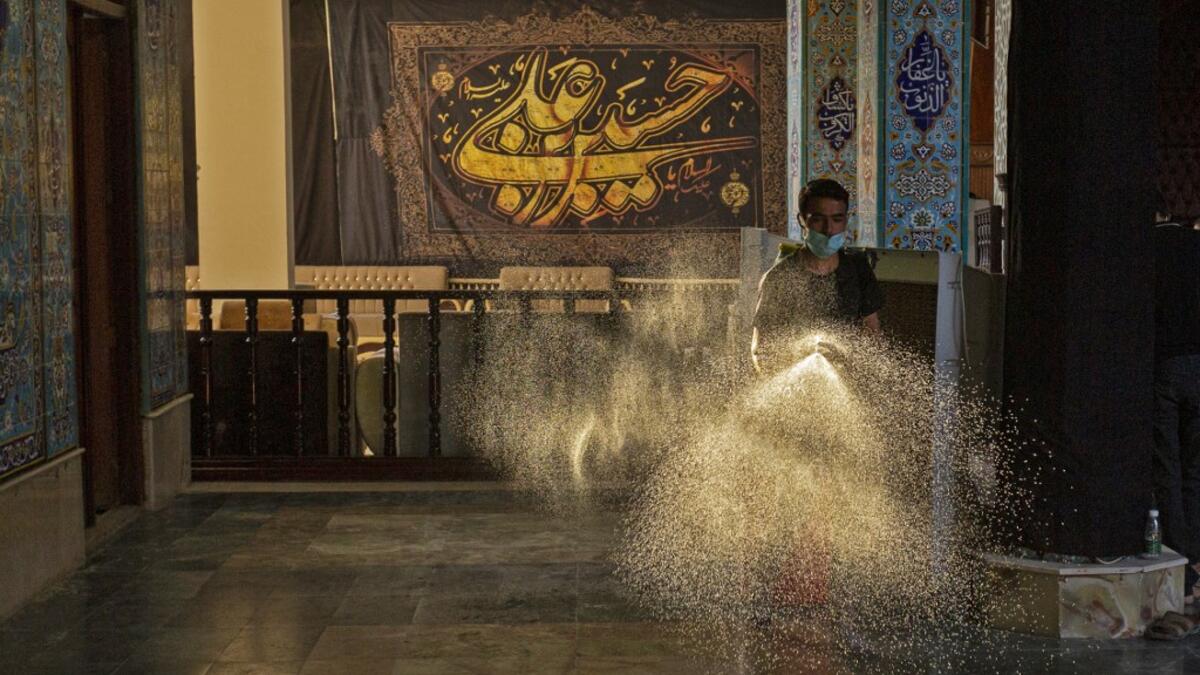 An Iraqi man disinfects a mosque on August 20, 2020, as Muslim Shiites start marking Ashura under new health guidelines to limit the risk of exposure to Covid-19 virus. Hussein FALEH / AFP