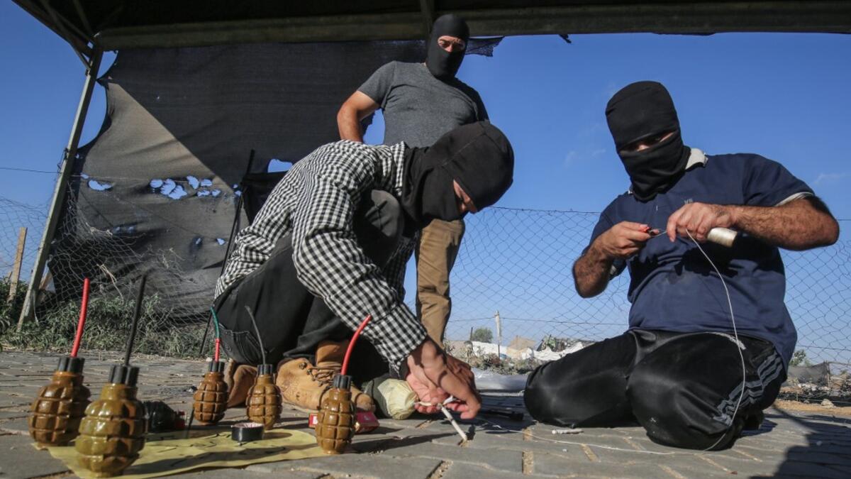 Palestinians prepare incendiary devices before being attached to inflated condoms and plastic bags, to be directed and flown towards Israel, near Rafah along the border between the Gaza Strip and Israel on August 21, 2020. SAID KHATIB / AFP