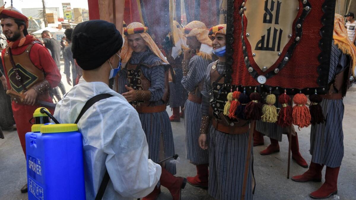 Ashura re-enactors in costume are doused, as a COVID-19 coronavirus pandemic precaution, while playing out a procession commemorating the entry of Imam Hussein and his family and retinue into Karbala, as Shiite Muslims mark the Ashura period in Iraq's central holy shrine city on August 22, 2020. Ashura is a period of mourning in remembrance of the seventh-century martyrdom of Prophet Mohammad's grandson Imam Hussein, who was killed in the battle of Karbala in modern-day Iraq, in 680 AD. Mohammed SAWAF / AFP