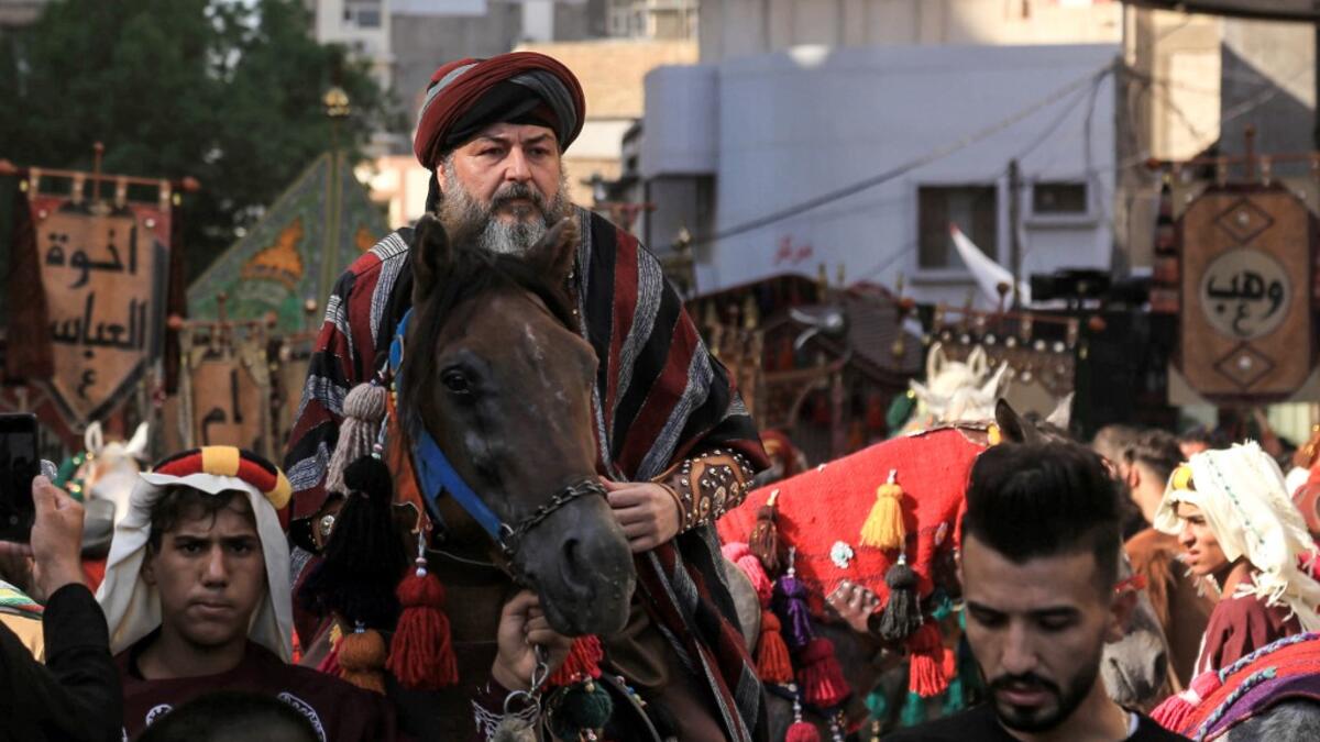 Ashura re-enactors in costume play out a procession commemorating the entry of Imam Hussein and his family and retinue into Karbala, as Shiite Muslims mark the Ashura period in Iraq's central holy shrine city on August 22, 2020. Ashura is a period of mourning in remembrance of the seventh-century martyrdom of Prophet Mohammad's grandson Imam Hussein, who was killed in the battle of Karbala in modern-day Iraq, in 680 AD. Mohammed SAWAF / AFP
