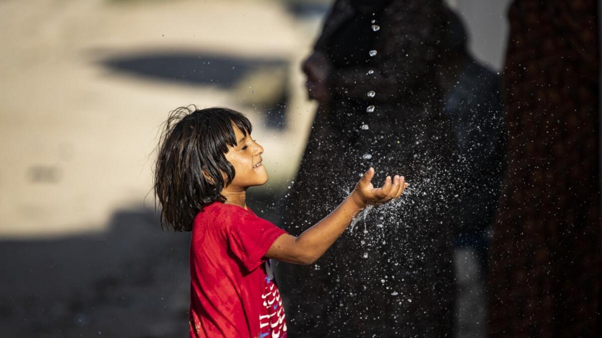 A Syrian boy plays with a stream of water, after humanitarian organisations delivered water to the area during a water outage, in Syria's northeastern city of Hasakah on August 22, 2020. As coronavirus spreads across northeast Syria, residents in Hasakeh have been caught up in the latest spat between Turkish forces to the north and Syrian Kurds it views as "terrorists". In October last year, Turkish forces occupied a 120-stretch (70-mile) stretch of land inside the Syrian border, including the Alouk power s