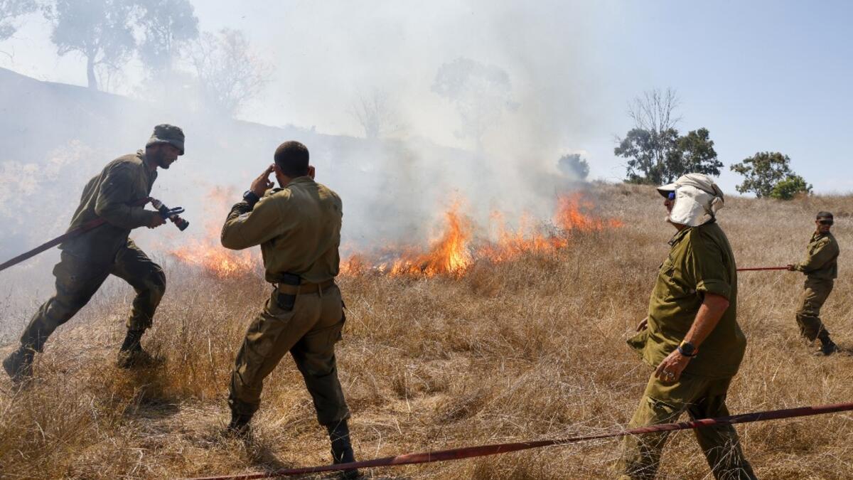 Israeli soldiers battle a blaze in a field close to the southern Israeli kibbutz of Nir Am near the border with the Gaza Strip on August 23, 2020, after it was reportedly set off by incendiary kites flown from the Palestinian enclave. menahem kahana / AFP