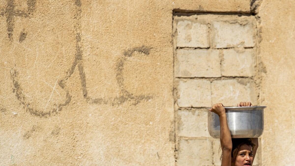 A displaced Syrian brings water back to their camp in a camp for the displaced in Syria's northeastern city of Hasakah on August 24, 2020. Delil SOULEIMAN / AFP