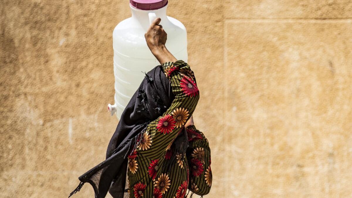 A displaced Syrian brings water back to their camp in a camp for the displaced in Syria's northeastern city of Hasakah on August 24, 2020. Delil SOULEIMAN / AFP