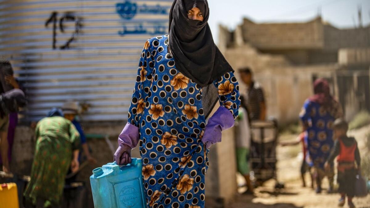 A displaced Syrian brings water back to their camp in a camp for the displaced in Syria's northeastern city of Hasakah on August 24, 2020. Delil SOULEIMAN / AFP