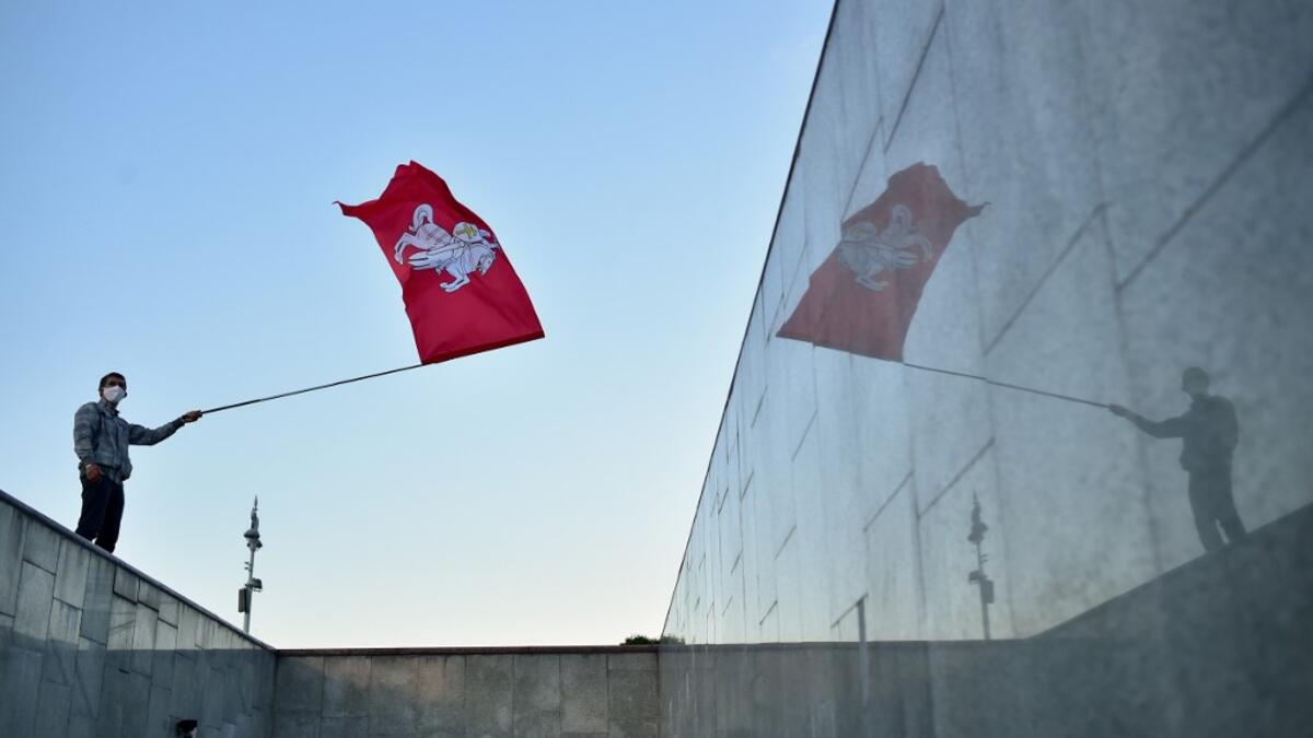 A man waves a flag during a rally of opposition supporters to protest against disputed presidential elections results in Minsk on August 24, 2020. Sergei GAPON / AFP