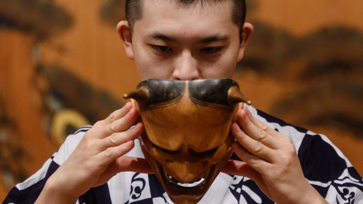 This photo taken on July 29, 2020 shows performer Kennosuke Nakamori putting on the "hannya" mask as he takes part in a rehearsal at the Kamakura Noh Theatre in the town of Kamakura in Kanagawa Prefecture, about one hour southwest of Tokyo. Philip FONG / AFP