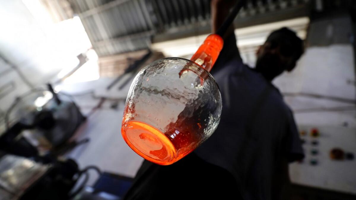 A glassblower forms glass at factory, which is recycling the broken glass as a result of the Beirut explosion, in the northern Lebanese port city of Tripoli on August 25, 2020. The August 4 port explosion ripped through countless glass doors and windows when it laid waste to whole Beirut neighbourhoods, killing at least 190 people and wounding thousands more. Volunteers, non-governmental groups and entrepreneurs salvaged a fraction of the tonnes of broken glass that littered the streets, some of it through