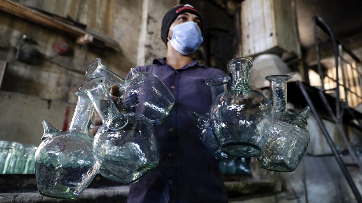 A worker washes jugs at a factory, which is recycling the broken glass as a result of the Beirut explosion, in the northern Lebanese port city of Tripoli on August 25, 2020. The August 4 port explosion ripped through countless glass doors and windows when it laid waste to whole Beirut neighbourhoods, killing at least 190 people and wounding thousands more. Volunteers, non-governmental groups and entrepreneurs salvaged a fraction of the tonnes of broken glass that littered the streets, some of it through rec