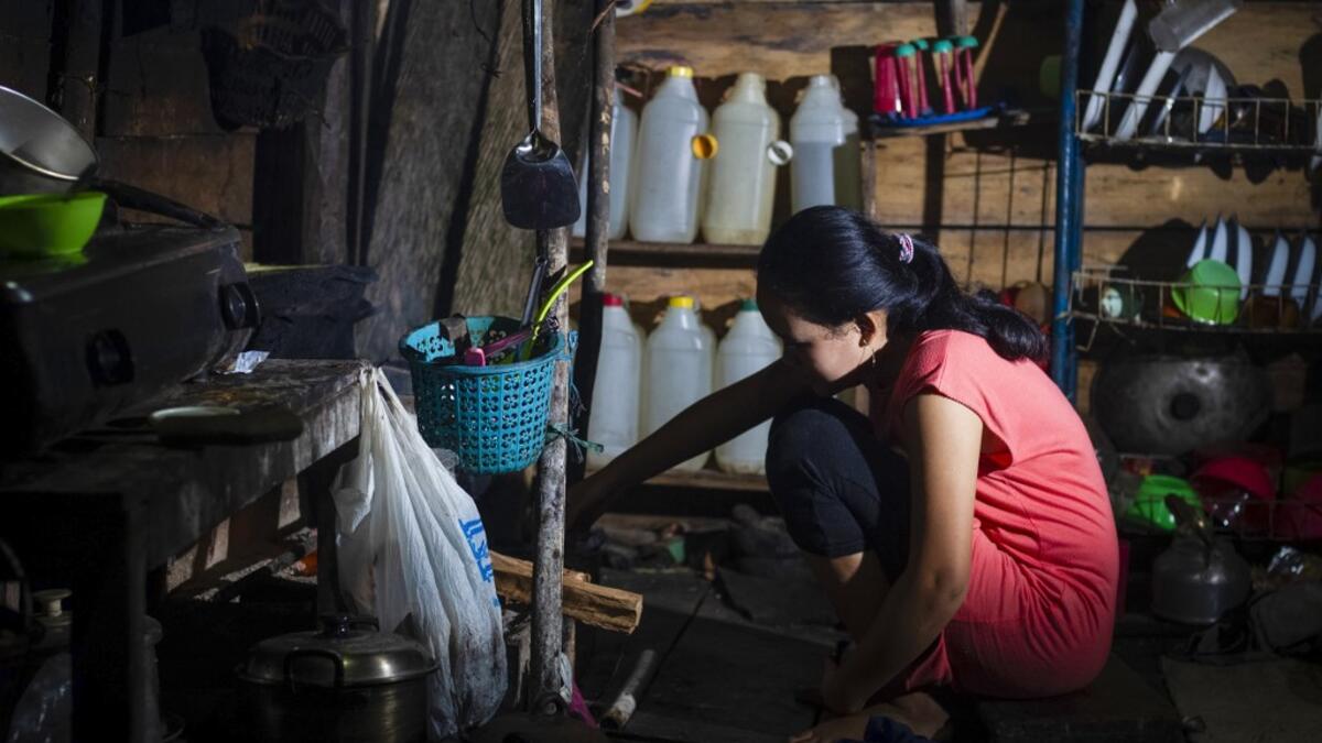 This picture taken on July 24, 2020 shows Tati (not her real name), who got married under age in March 2020, cooking in her kitchen in North Botteng in Mamuju, West Sulawesi. Child marriage has long been common in traditional communities from the Indonesian archipelago to India, Pakistan and Vietnam, but numbers had been decreasing as charities made inroads by encouraging access to education and women's health services. YUSUF WAHIL / AFP