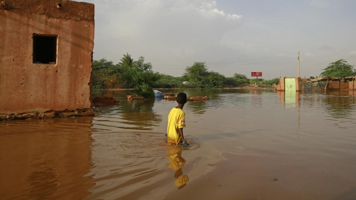 A Sudanese boy wades through a flooded street at the area of al-Qamayir in the capital's twin city of Omdurman, on August 26, 2020.ASHRAF SHAZLY / AFP