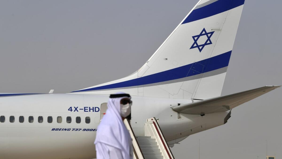 An Emirati official stands near an air-plane of El Al, which carried a US-Israeli delegation to the UAE following a normalisation accord, upon it's arrival at the Abu Dhabi airport in the first-ever commercial flight from Israel to the UAE, on August 31, 2020. KARIM SAHIB / AFP