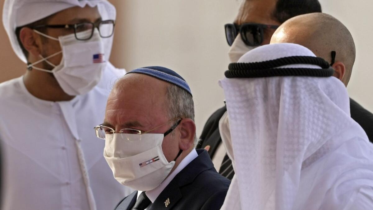 The Head of Israel's National Security Council, Meir Ben-Shabbat (C), wearing a facemask to avoid the spread of the Covid-19 coronavirus, walks alongside an Emirati official at Abu Dhabi airport following the arrival of the first-ever commercial flight from Israel to the UAE, on August 31, 2020. KARIM SAHIB / AFP